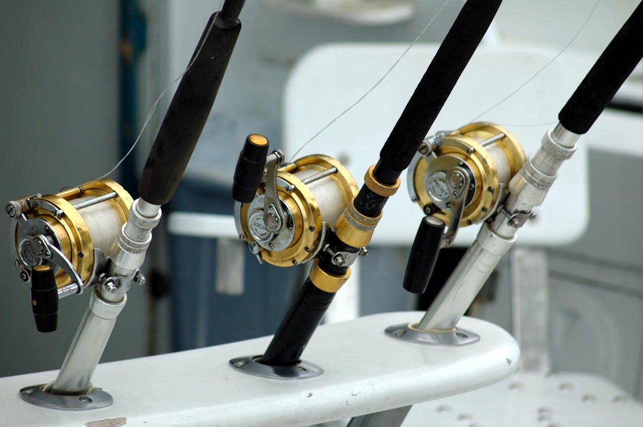 hero-img-02 Detailed view of fishing rods with gold reels on a boat, ideal for angling enthusiasts.